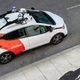 A GM Cruise robotaxi parks on the side of a road in a press image